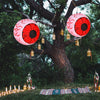 Two inflatable Halloween eyeballs with red LED lights, creating a spooky atmosphere in a festive outdoor setting.