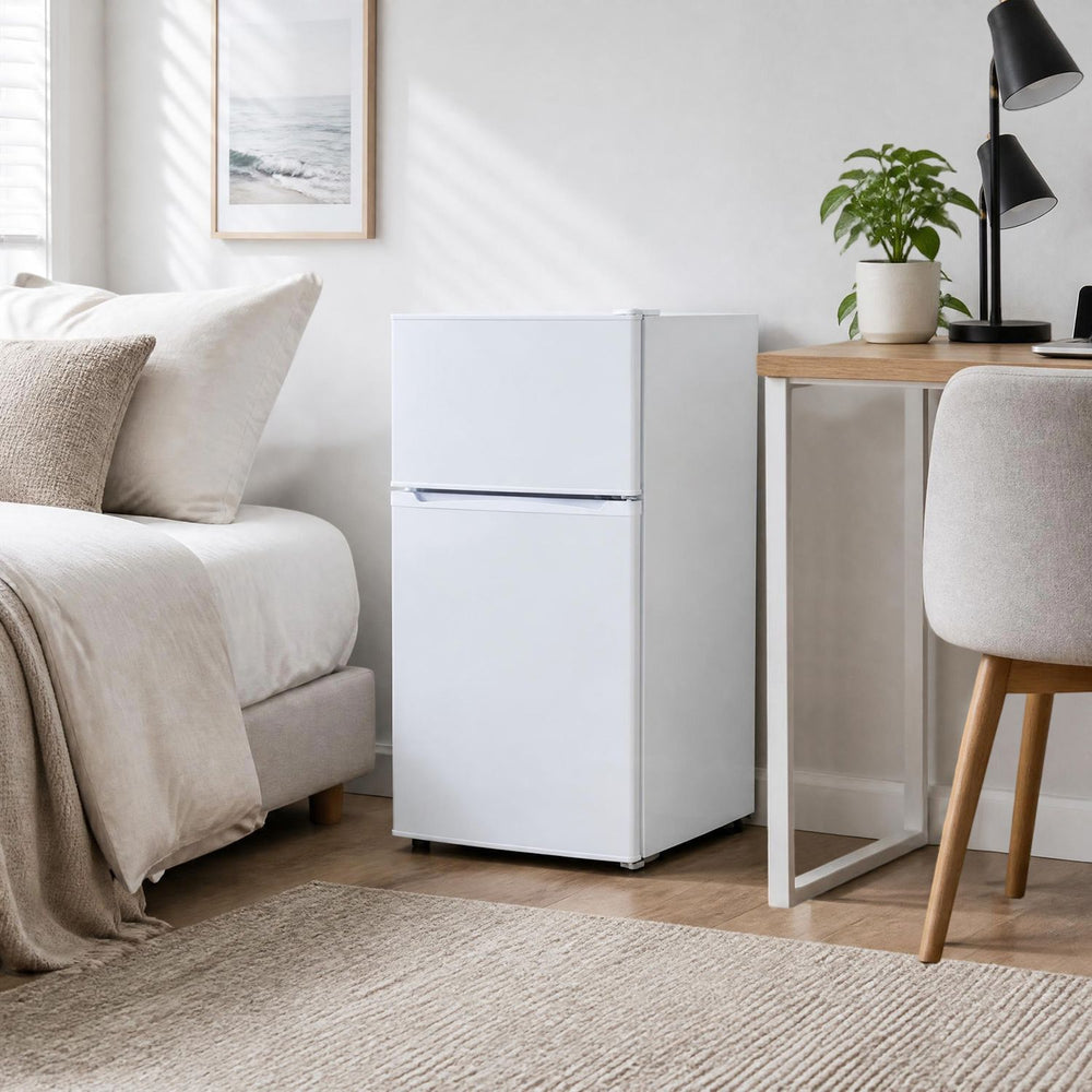 Mini 2-door refrigerator in white with 3.5 cu.ft capacity, adjustable shelves, and low-noise operation for convenient storage.