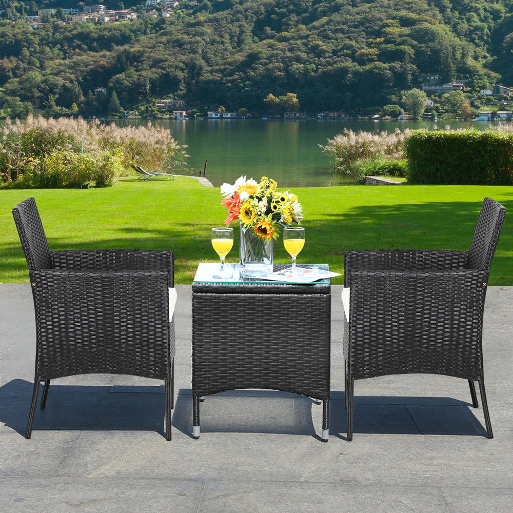 Two patio wicker chairs with cozy seat cushions, featuring a sturdy steel frame, ideal for outdoor relaxation by the.
