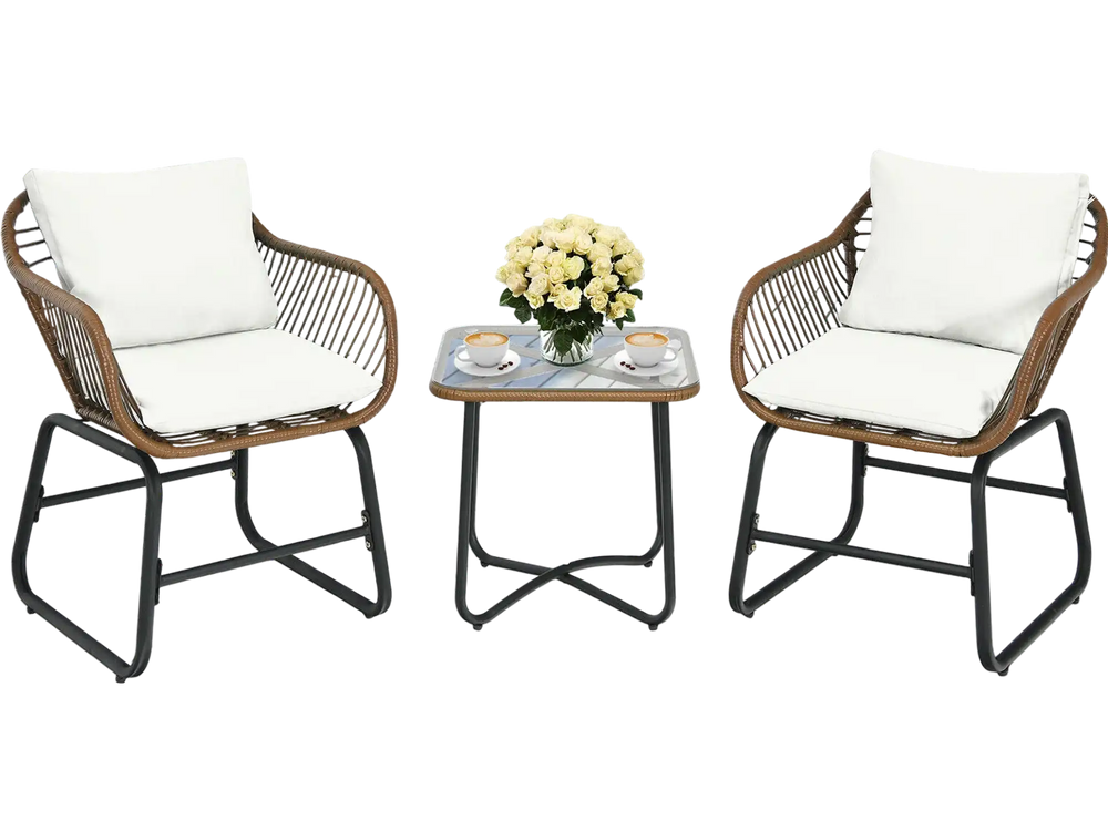 Two cushioned rattan chairs and a glass table in a patio setting, perfect for outdoor relaxation and leisure time.