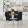 Four black PVC leather dining side chairs with painted steel legs around a wooden table in a modern kitchen setting.