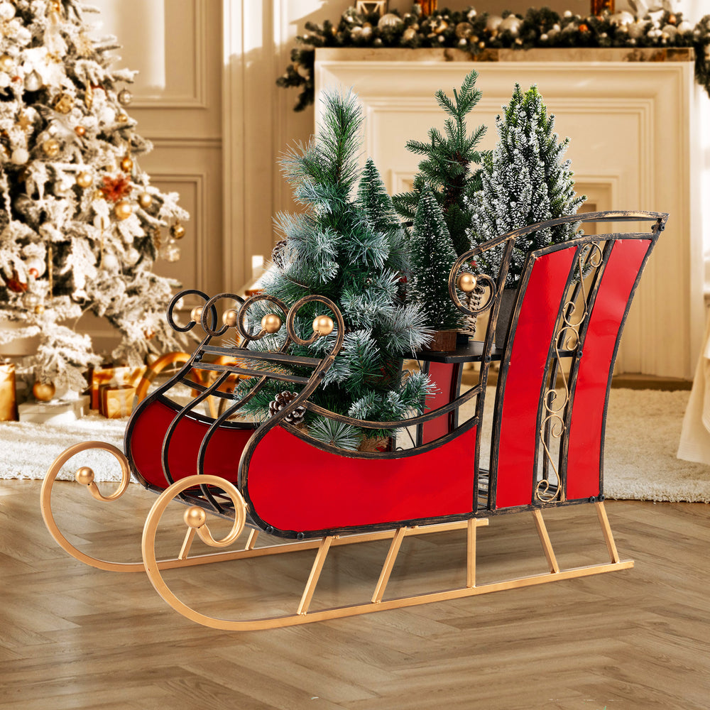 Christmas metal sleigh decoration in vibrant red with black and gold scrollwork, featuring a 2-tier storage shelf for.