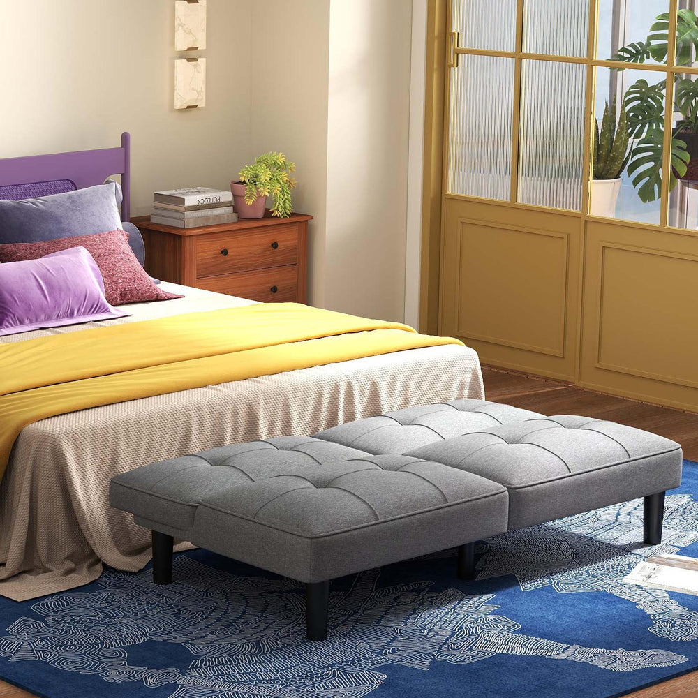 Convertible folding futon sofa bed in gray with padded cushions, perfect for relaxation and extra sleeping space.