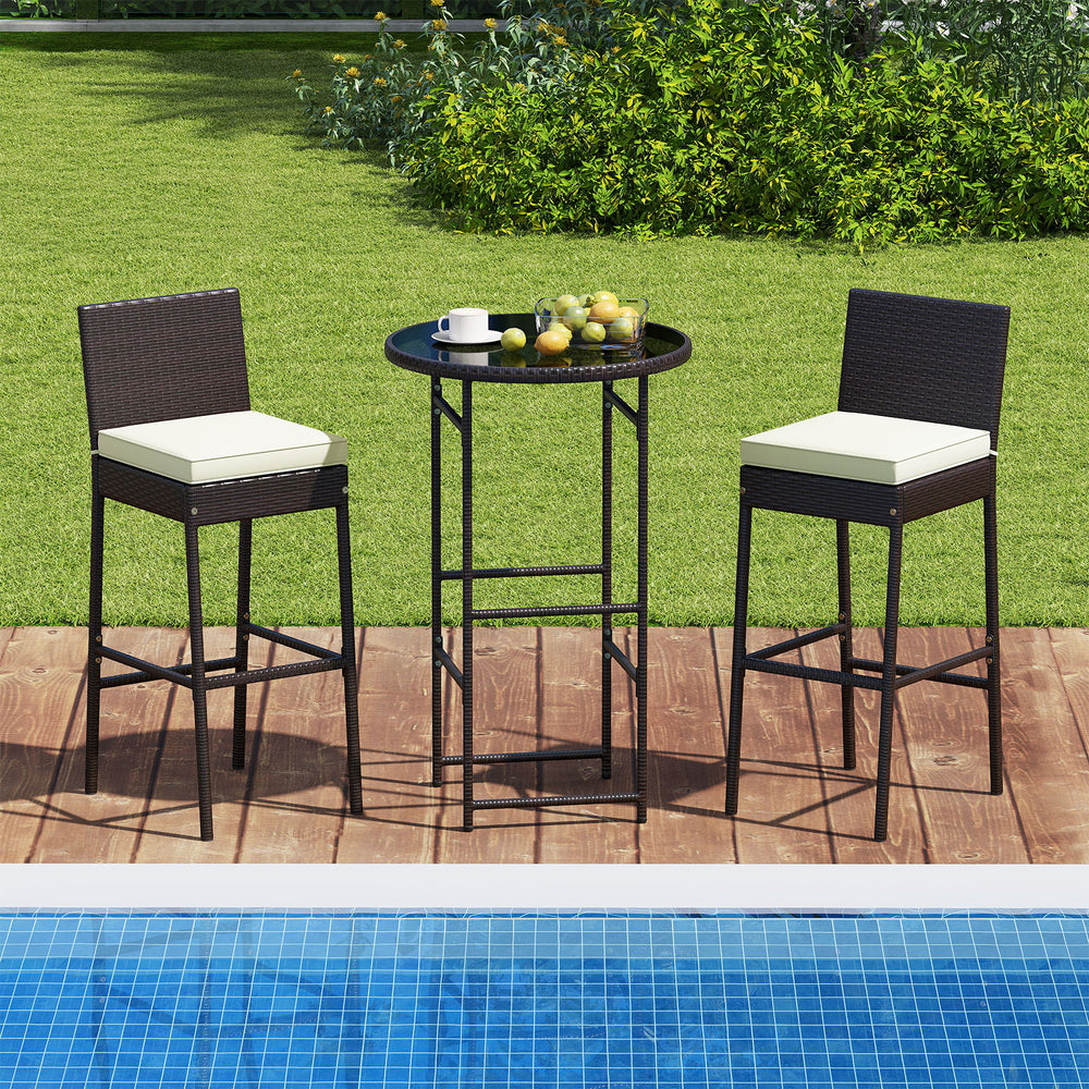 Outdoor bar set featuring two high stools with cushions and a round table, perfect for poolside relaxation.