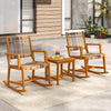 Two acacia wood rocking chairs with rattan seats and a compact side table, perfect for backyard relaxation.