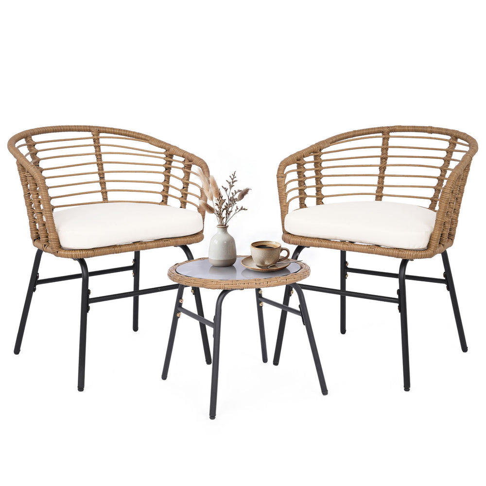 Two outdoor patio chairs with soft cushions and a round bistro table, made of hand-woven PE rattan for garden use.