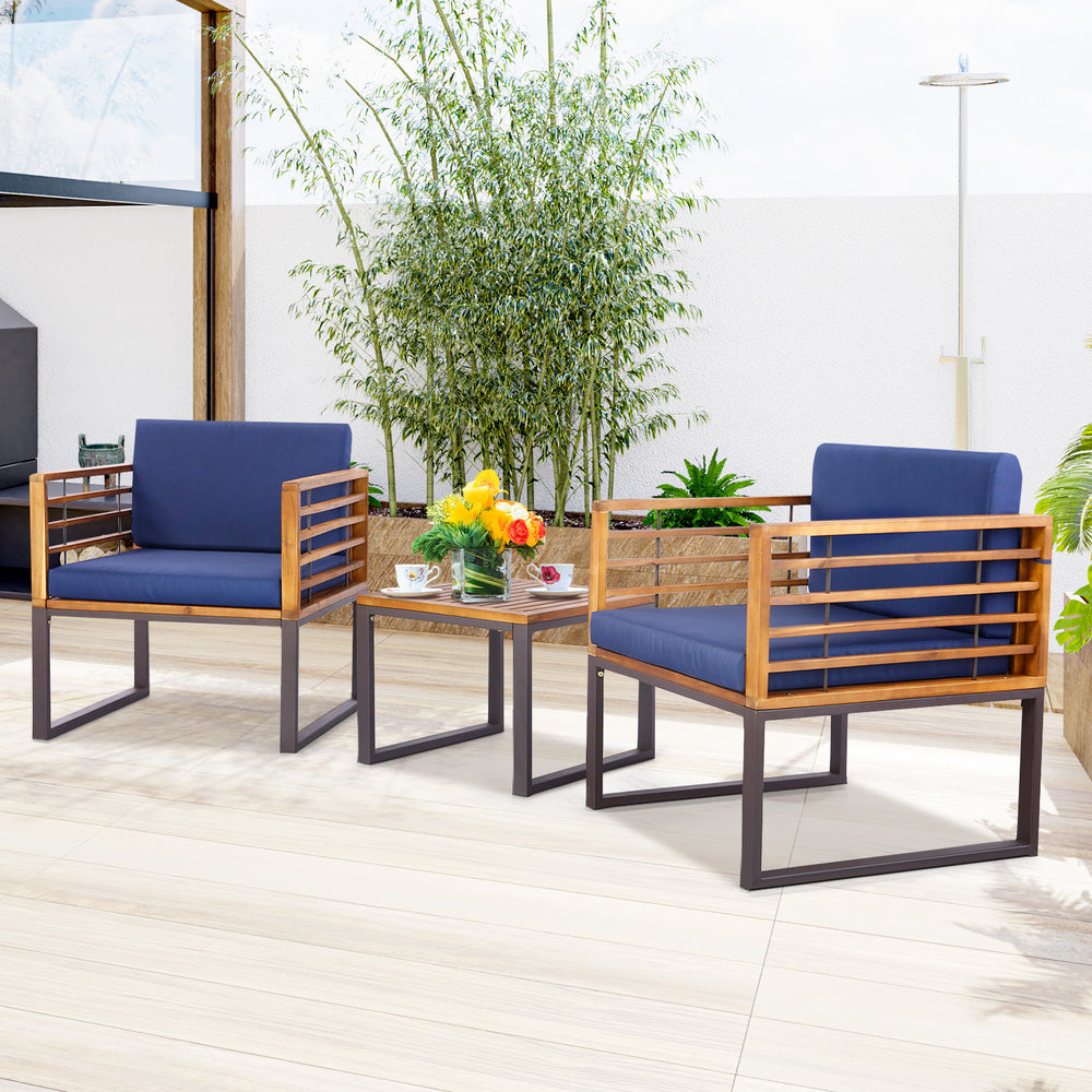 Acacia wood patio conversation set with navy cushioned armchairs and a coffee table, perfect for outdoor relaxation.
