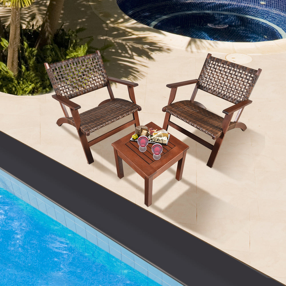 Two outdoor wooden armchairs with rattan seats and a solid wood coffee table, perfect for patio or poolside relaxation.
