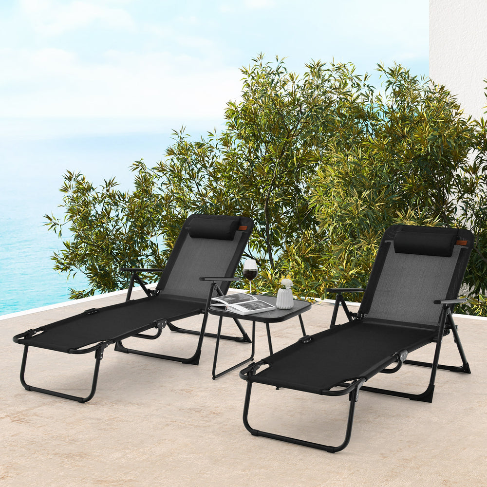 Black folding chaise lounge with adjustable backrest and padded pillow, ideal for comfortable outdoor lounging and.