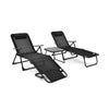 Two black folding chaise lounges with a faux marble table, perfect for outdoor relaxation and sunbathing.