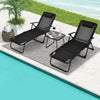 Two black folding chaise lounges with a faux marble table, perfect for relaxing by the poolside.