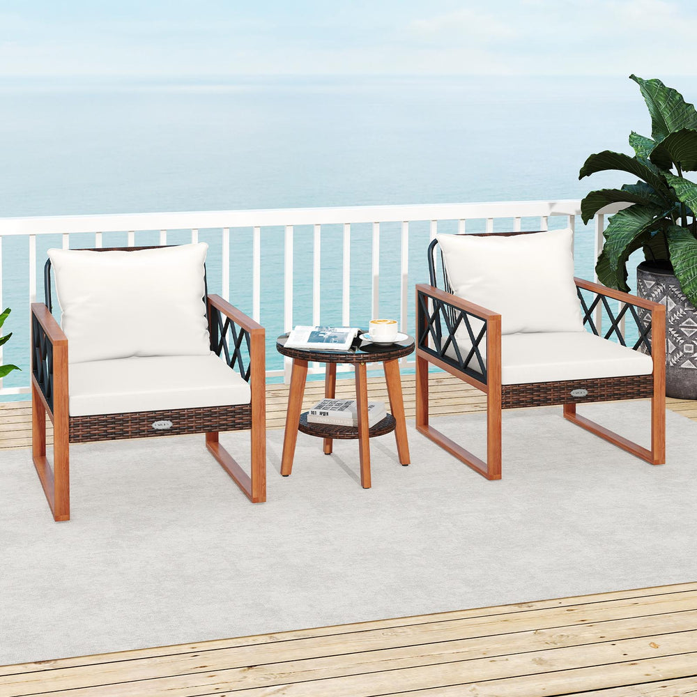 Two acacia wood chairs with soft off-white cushions and a tempered glass top table, perfect for outdoor relaxation.
