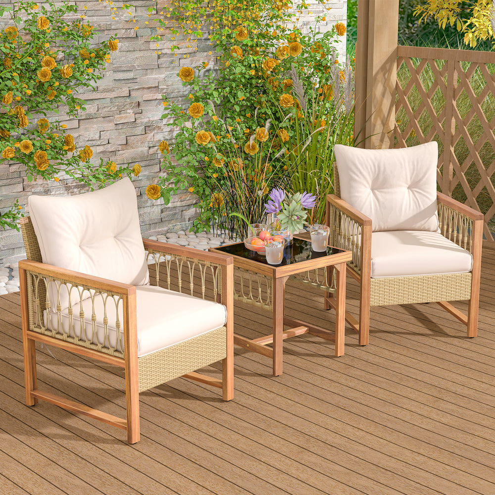 Two chairs with soft cushions and a glass-top table in a patio furniture set, featuring acacia wood and PE rattan.