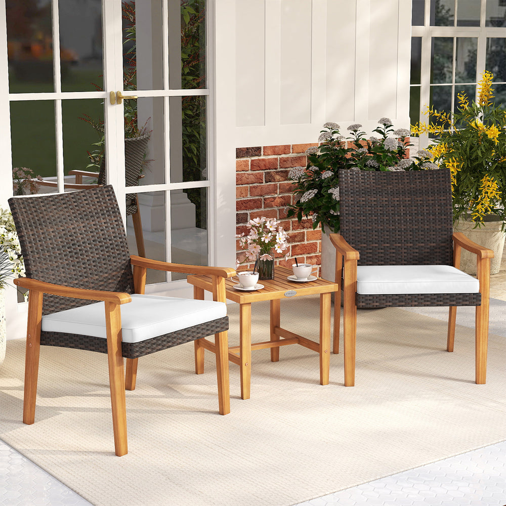 Two acacia wood chairs with white cushions and a square coffee table in a patio setting, perfect for outdoor.