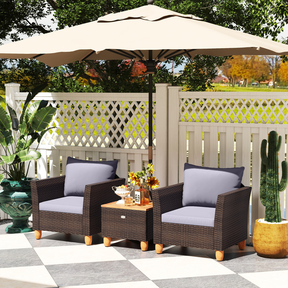 Two gray cushioned chairs and a wooden-top coffee table in a patio setting, perfect for outdoor relaxation.