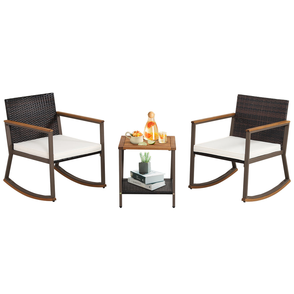 3-piece rattan rocking bistro set with off-white cushions and a double-tier coffee table for outdoor relaxation.