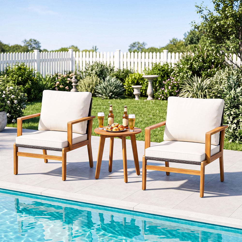 Two off-white cushioned chairs and a round acacia wood table, perfect for outdoor patio relaxation by the poolside.