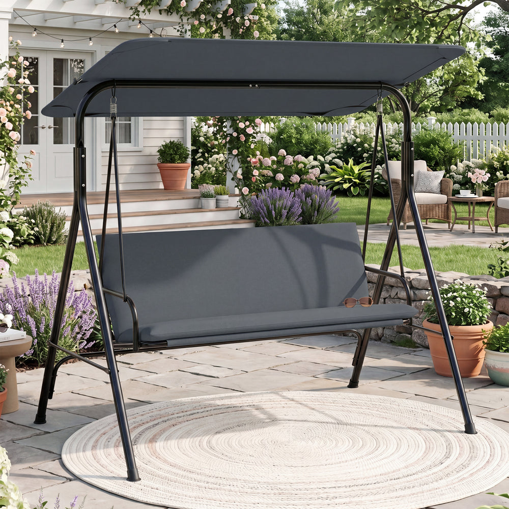 Gray 3-seat patio swing chair with a tilt canopy and soft cushions, designed for comfortable outdoor lounging.