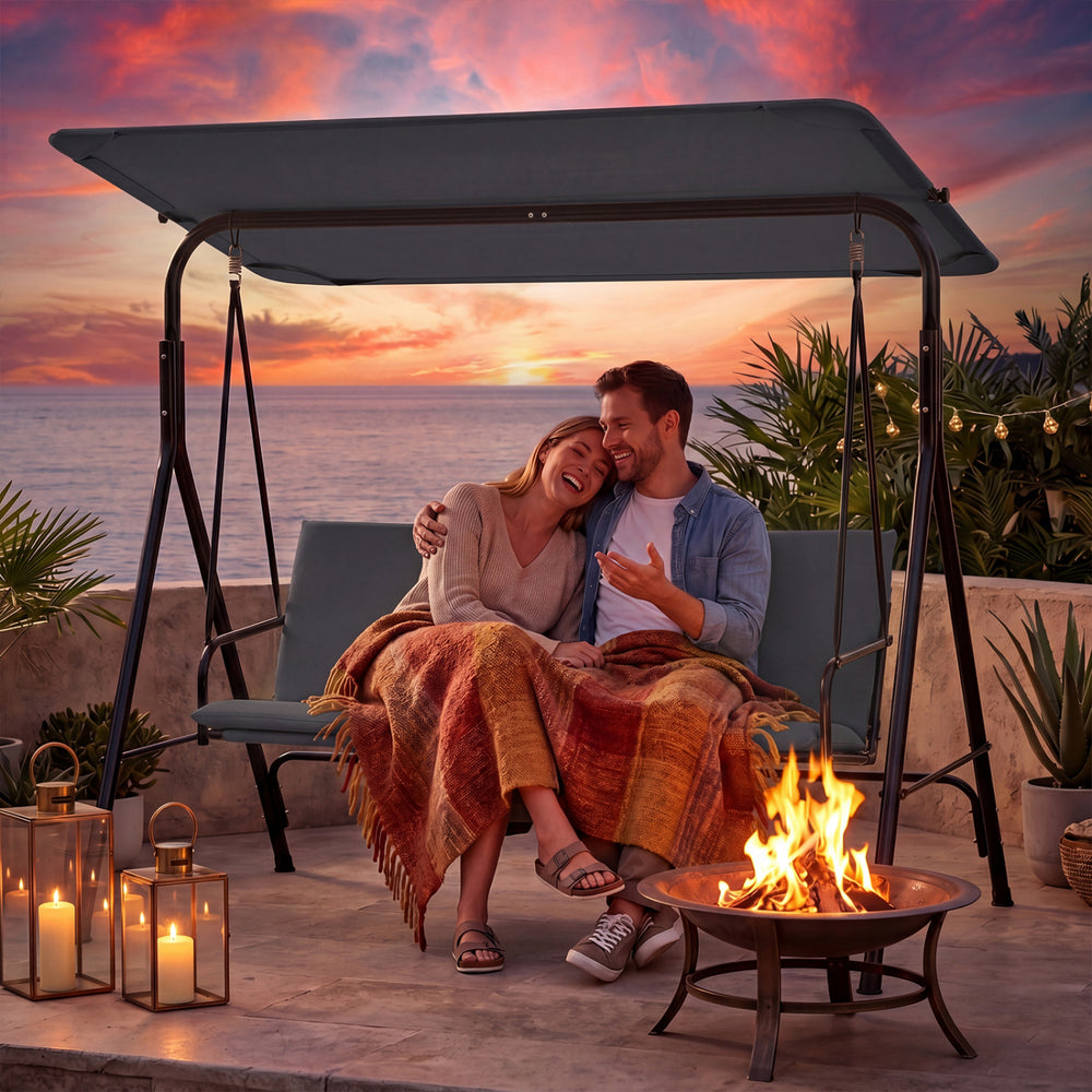 Cozy couple enjoying the 3-seat patio swing chair with adjustable canopy at sunset, perfect for outdoor relaxation.