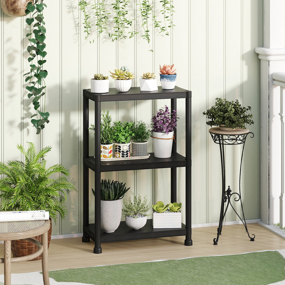 3-tier heavy-duty plastic storage shelves in black, featuring plants and pots, ideal for garage or indoor use.