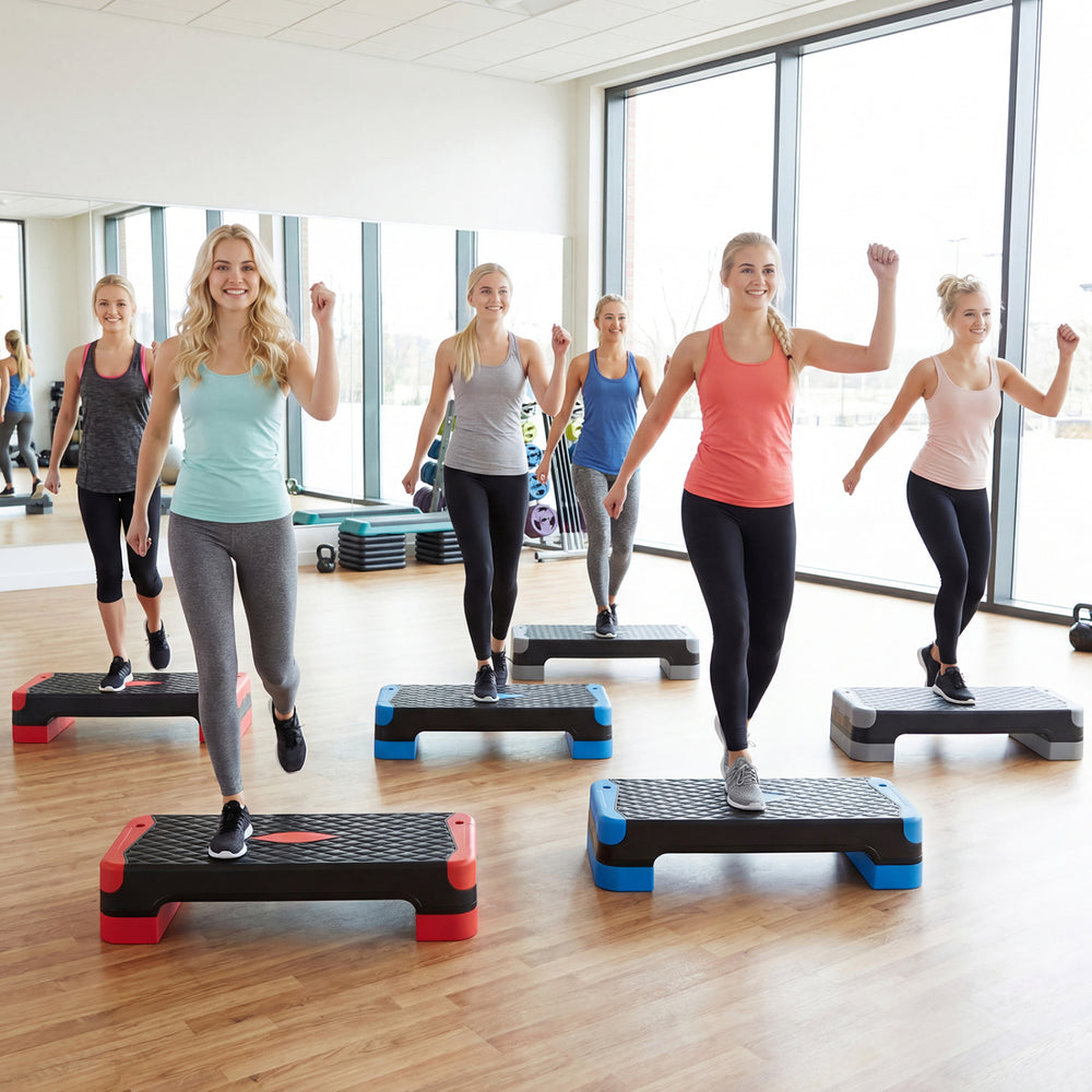 Group of women using the 3-in-1 aerobic step platform set for fitness training in a bright gym environment.