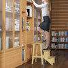 Rubber wood step stool with anti-slip surface, used as a ladder for easy access to high shelves in natural finish.