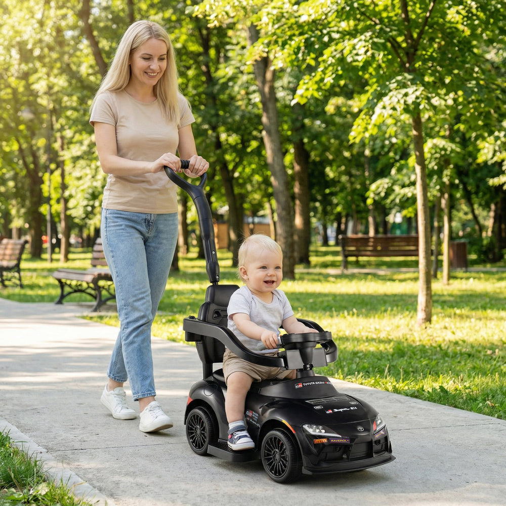 3-in-1 black Toyota licensed foot-to-floor stroller toy with parent handle, featuring a toddler securely seated.