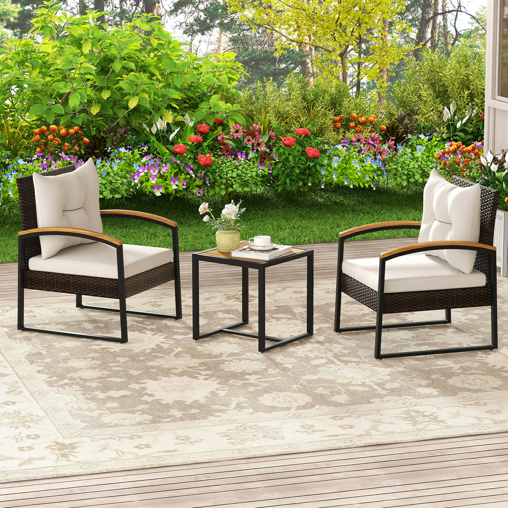 Two chairs with white cushions and acacia wood armrests, paired with a square table, perfect for outdoor patio.