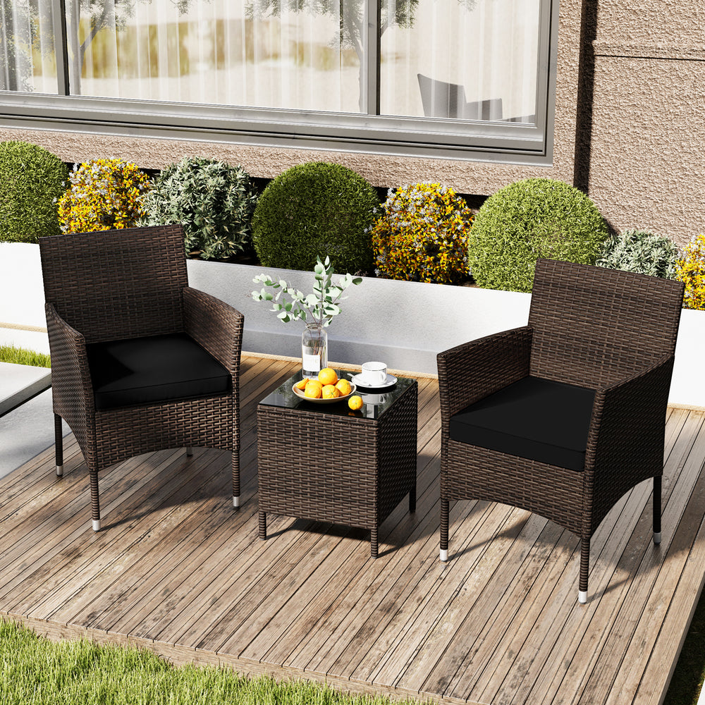 Outdoor conversation set featuring two cushioned chairs and a square glass tabletop, perfect for backyard relaxation.