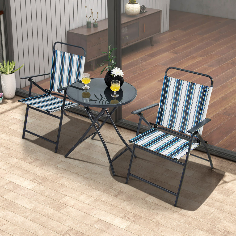 Two striped folding chairs and a round table set on a patio, perfect for backyard or poolside relaxation.