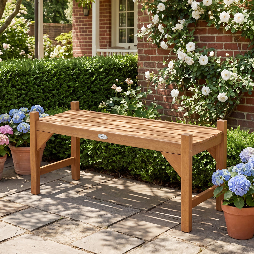 40-inch outdoor bench with slatted contoured seat, placed in a garden setting among flowers for deck entryway use.