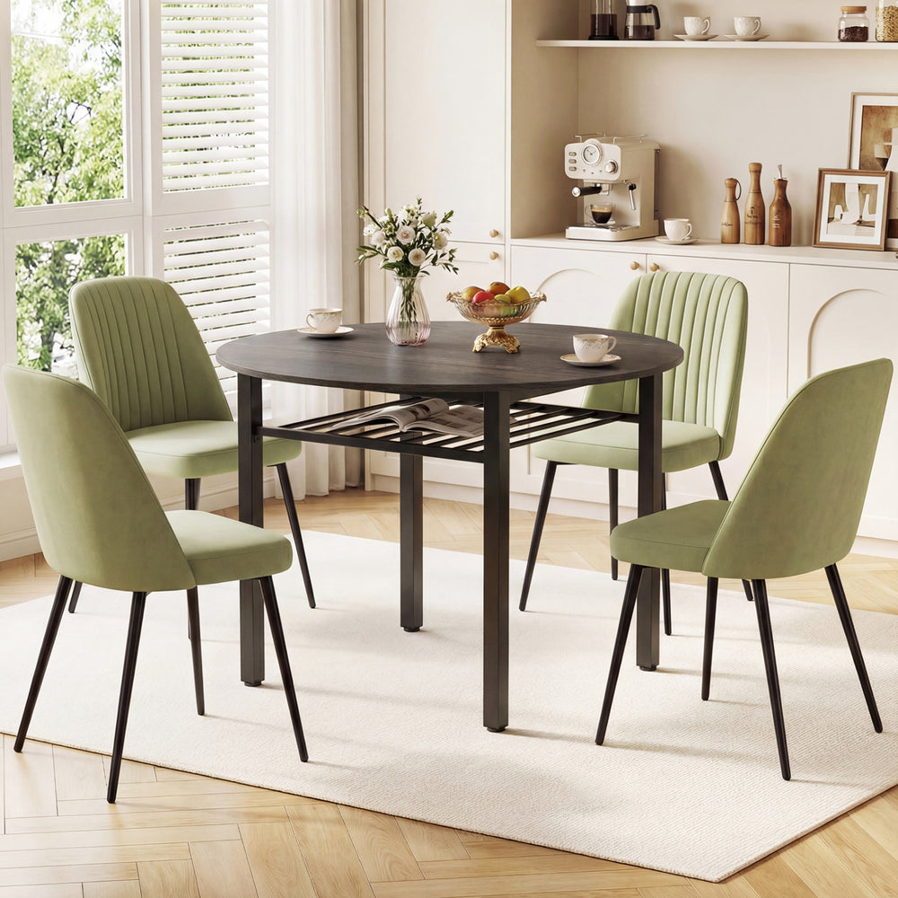 Round gray kitchen table set for four with metal frame and storage shelf, featuring green upholstered chairs in a.