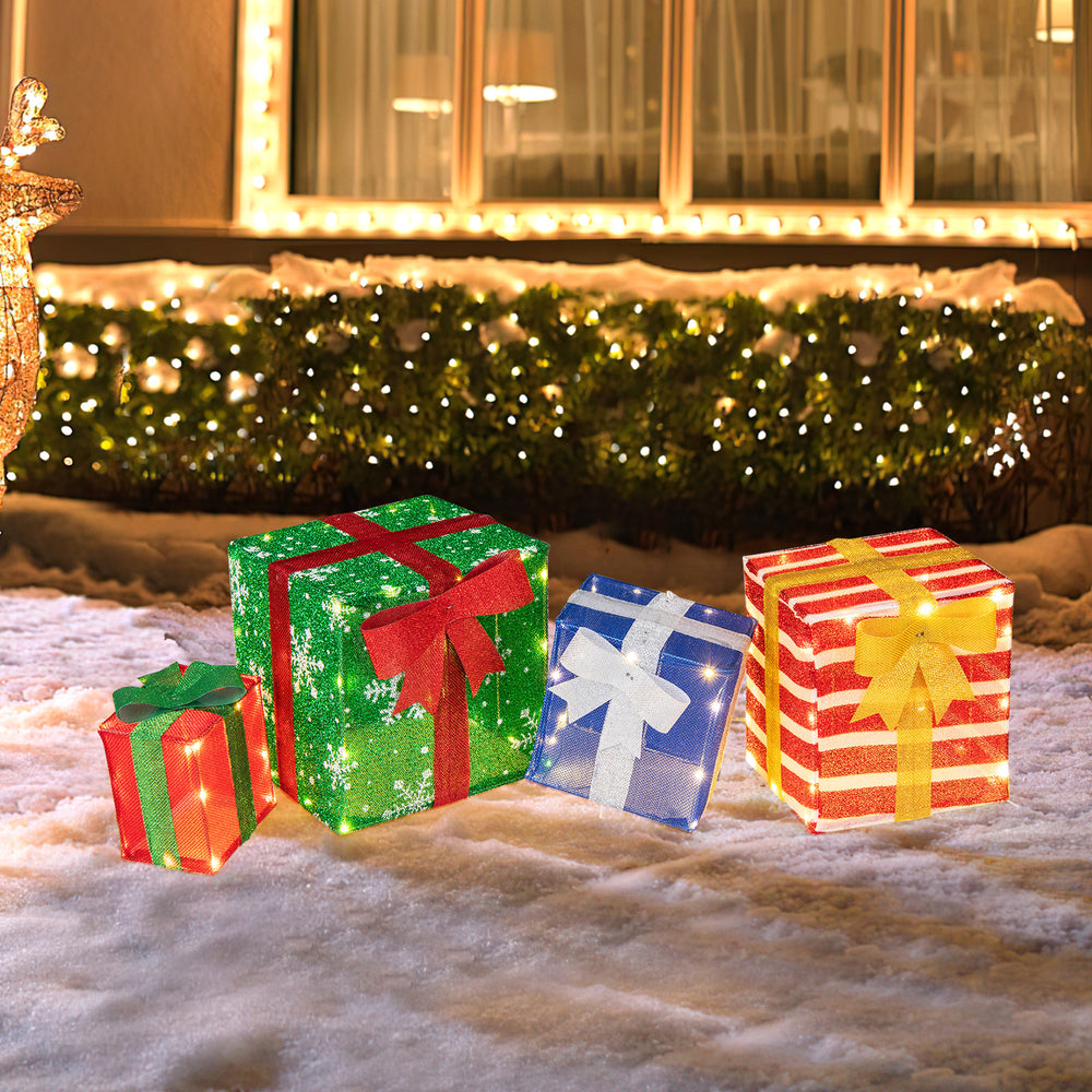 Colorful stacked gift boxes with LED lights and bows, perfect for enhancing holiday spirit in outdoor or indoor.