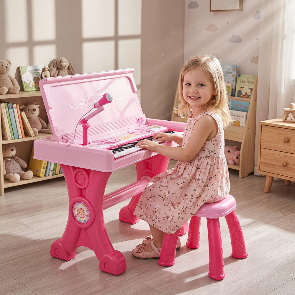 Kids electric piano keyboard toy in pink with 49 keys, microphone, and stool for engaging musical play.
