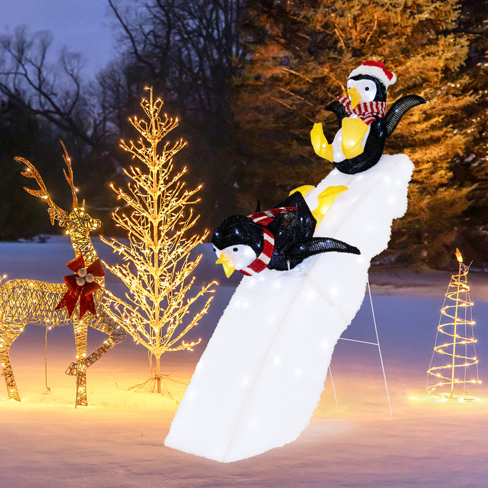 4 feet Christmas penguin decor on a snowy slide with 130 LED lights, perfect for festive indoor or outdoor decoration.
