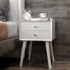 Mid-century white wooden nightstand with two storage drawers, perfect for bedside decor and efficient space use.