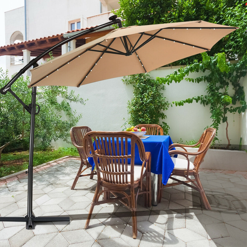 Beige 10 ft patio offset umbrella showcasing a 360° rotation mechanism, positioned beside a dining table and chairs for.