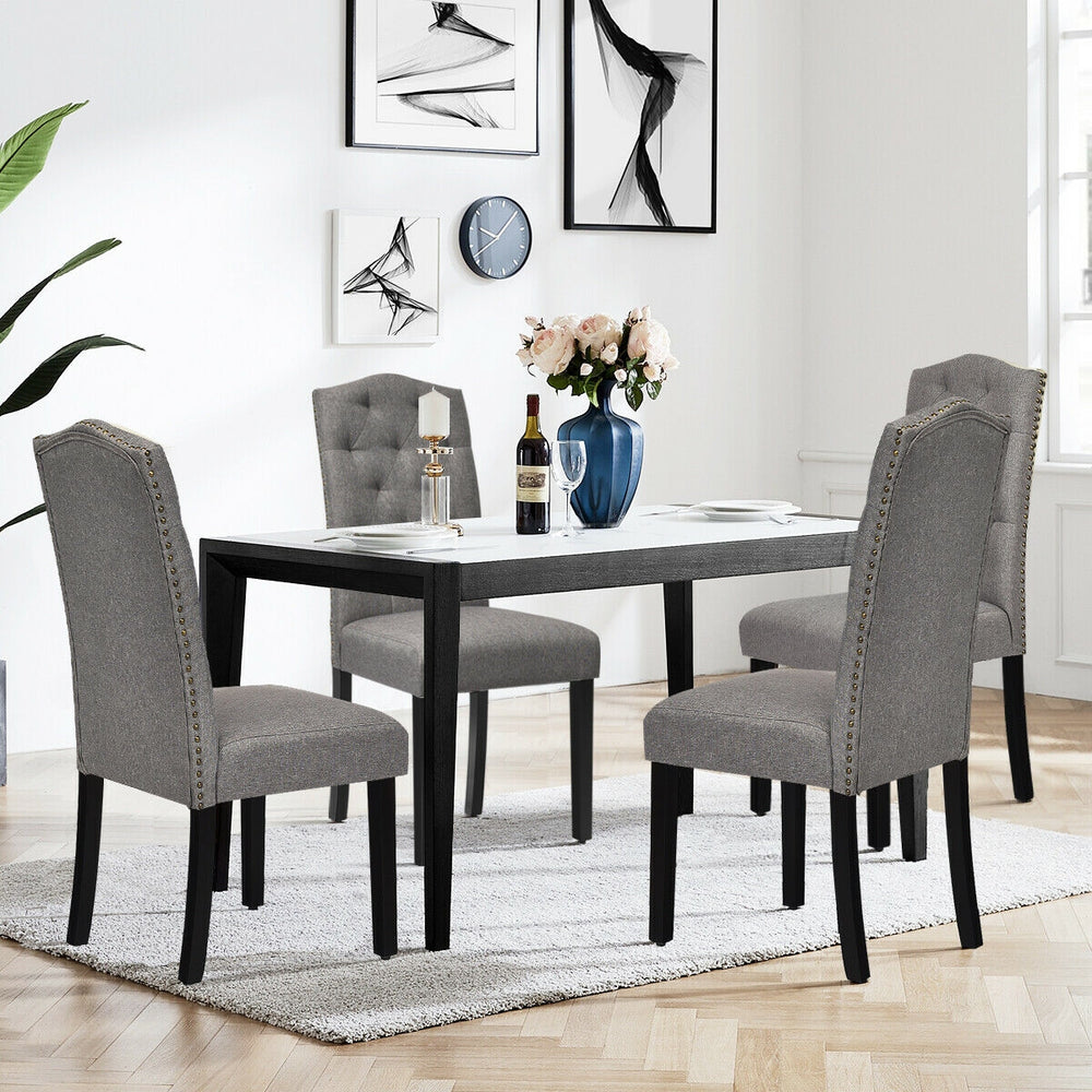 Tufted upholstered dining chairs in gray with rubberwood legs, perfect for home or café use, providing comfort and.