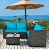 Turquoise cushioned loveseat and coffee table from a 4-piece outdoor patio rattan furniture set, ideal for garden use.