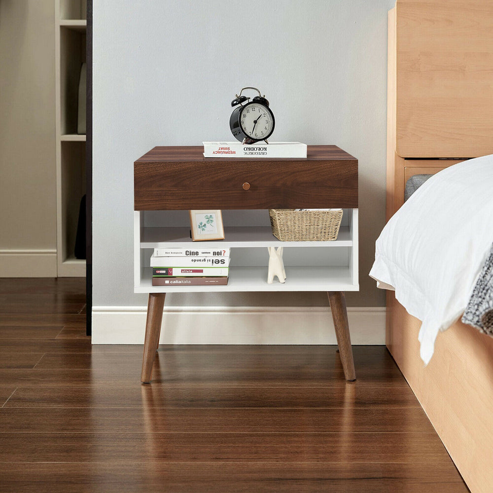 Mid-century nightstand with a drawer and rubber wood legs, featuring open shelves for storage beside a bed.