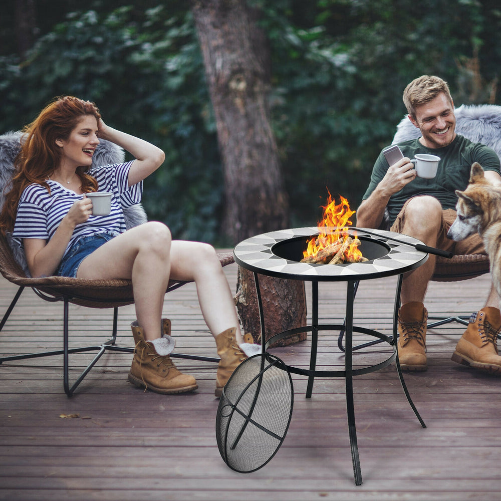 Round fire pit table with mesh cover and fire poker, perfect for outdoor gatherings on patio or backyard.