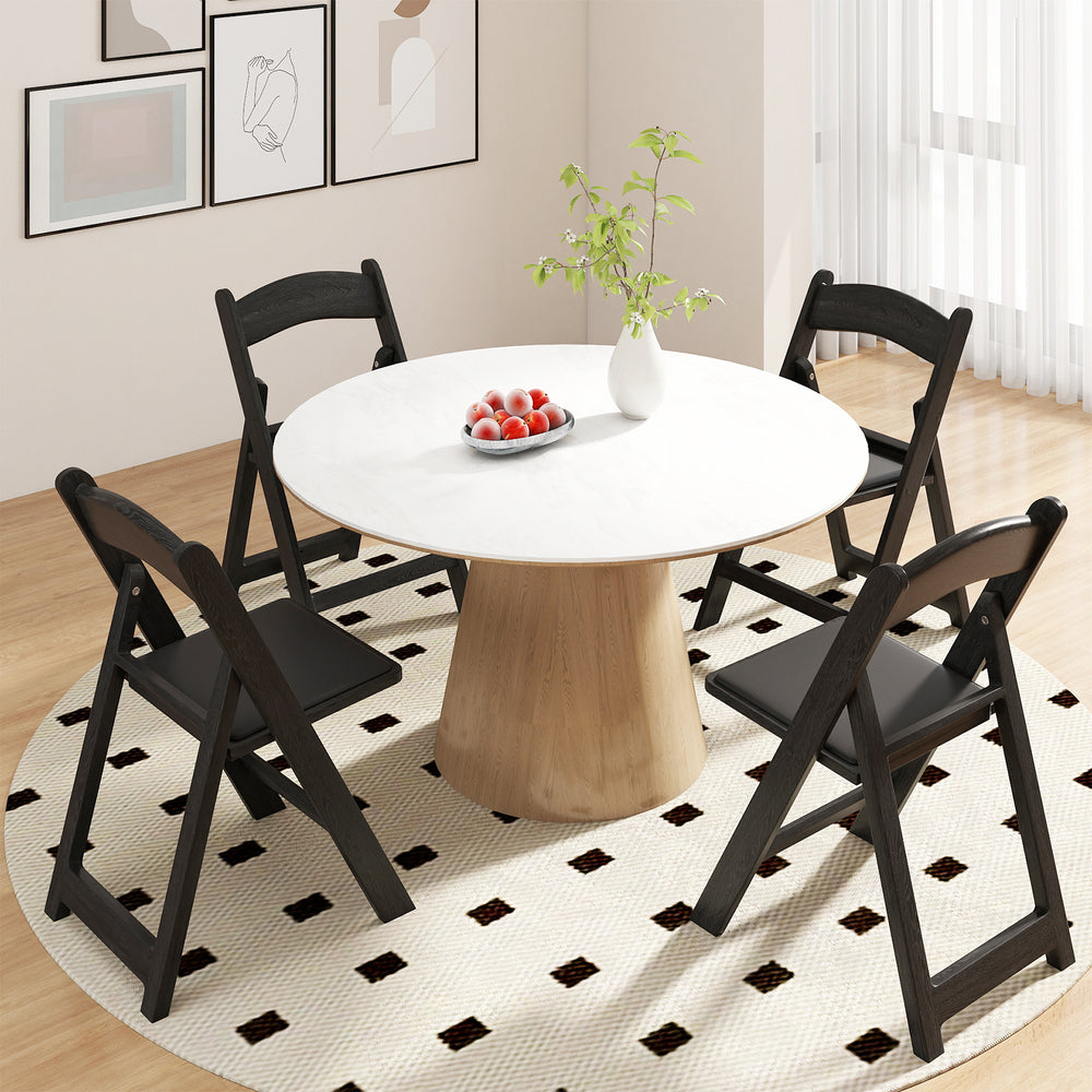 Black resin folding chairs with padded seats arranged around a round table, perfect for events and easy storage.