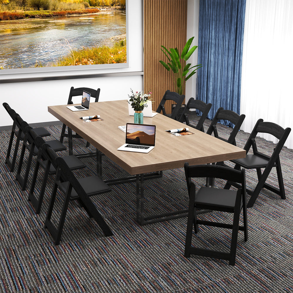 Black resin folding chairs with padded seats arranged around a large table, ideal for events like weddings and parties.