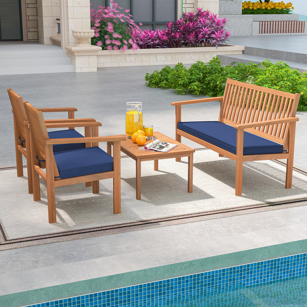 Acacia wood 4-piece patio furniture set with navy cushions, perfect for poolside relaxation and outdoor gatherings.