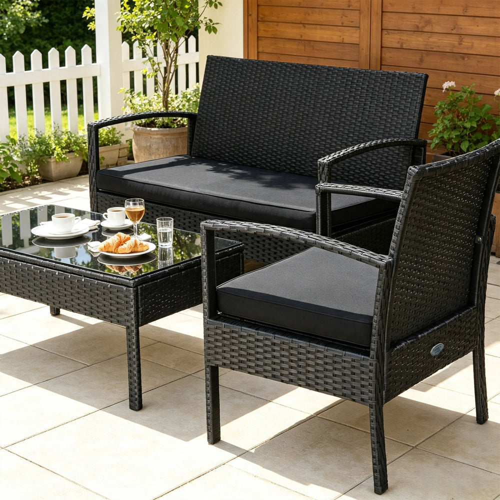 Patio rattan furniture set featuring a loveseat, two single sofas, and a coffee table with black cushions for outdoor relaxation.