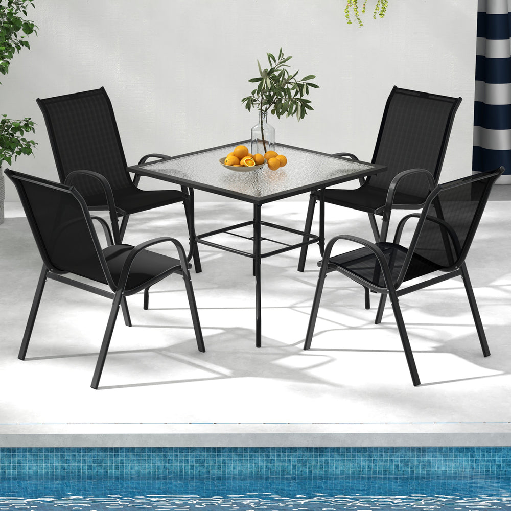Four stackable black patio dining chairs with armrests, featuring ergonomic design and lightweight structure for.
