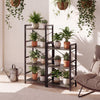 Narrow 4-tier bookshelf with metal frame in oak, showcasing plants and decorative items in a stylish indoor setting.