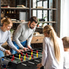 Family enjoying the 4-in-1 Multi Game Table featuring foosball, billiards, and table tennis for fun game nights.