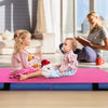 Children sitting on a pink 4ft x 4ft x 4in bi-folding gymnastic tumbling mat, ideal for play and exercise.