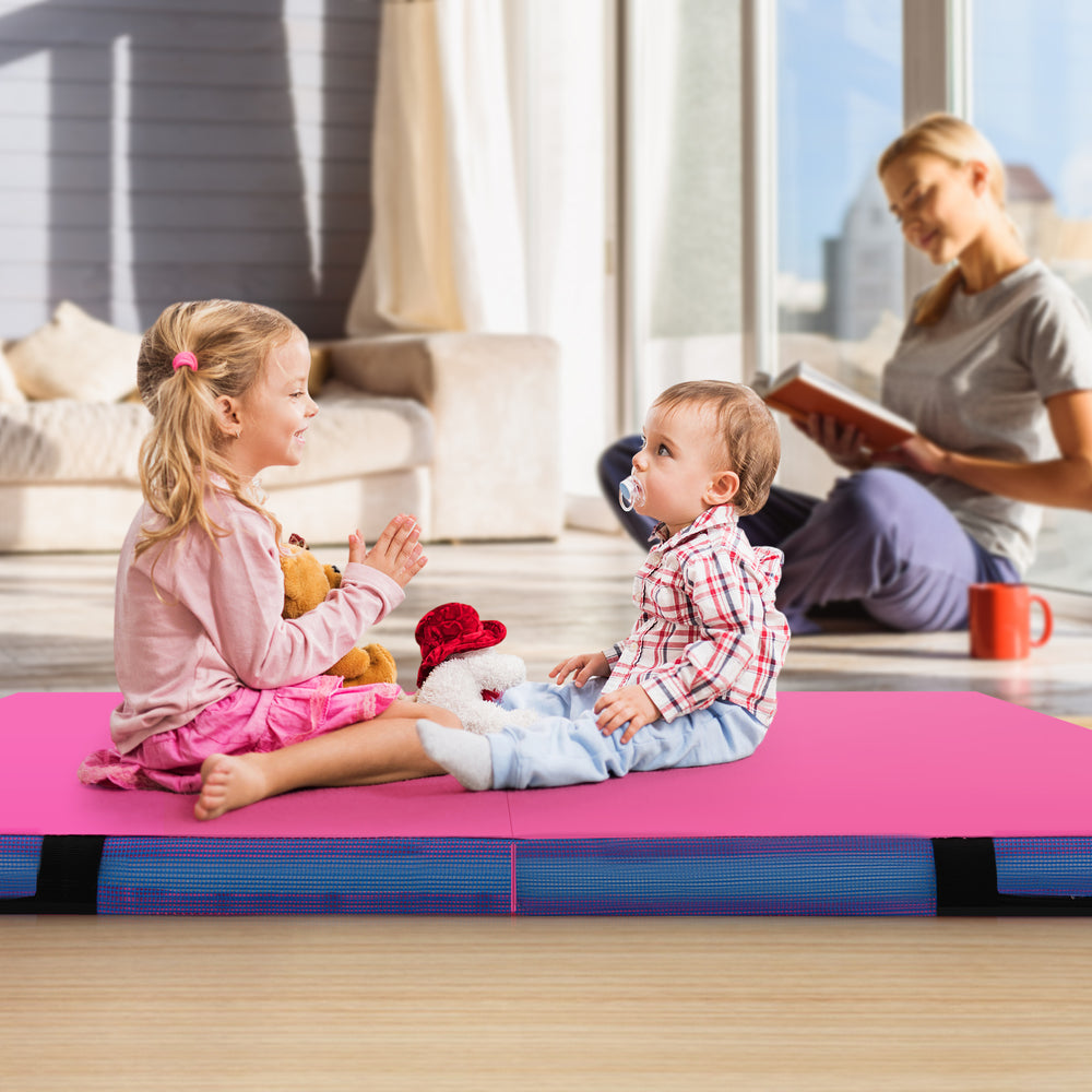 Children sitting on a pink 4ft x 4ft x 4in bi-folding gymnastic tumbling mat, ideal for play and exercise.